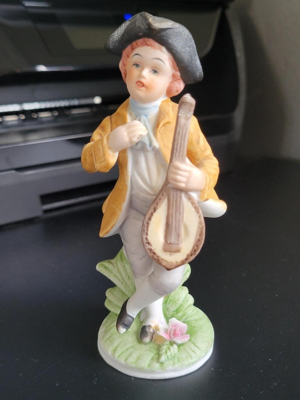 Vintage bisque ceramic figurine of a boy playing a mandolin